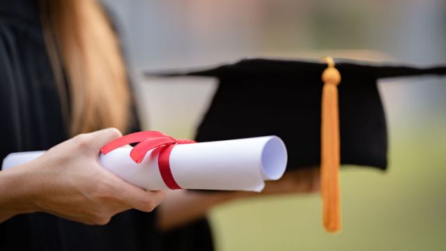 a student carrying his high school diploma