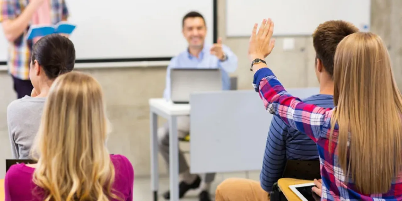 A student raising their hand to answer a question.