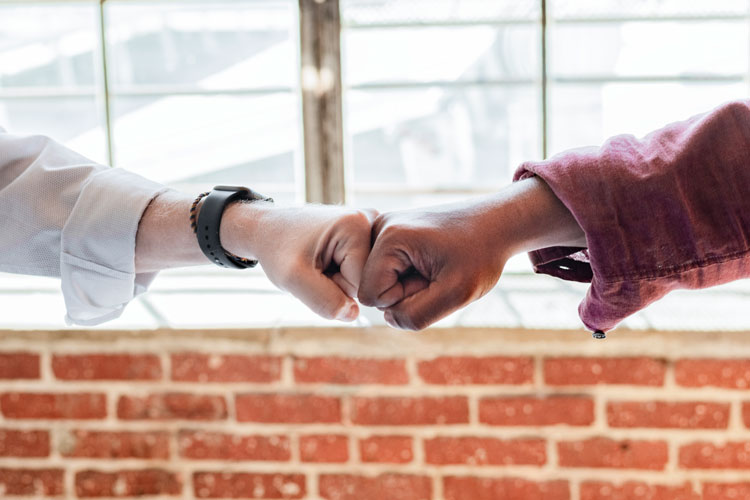 two people hand bumping