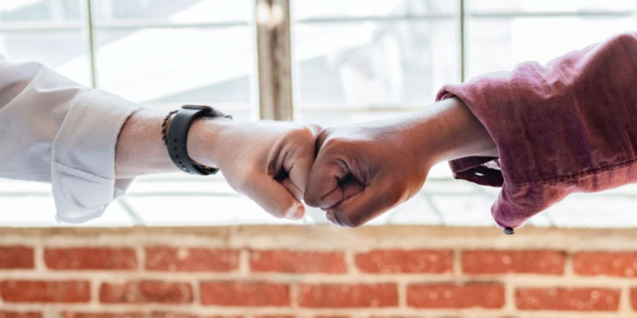 two people hand bumping