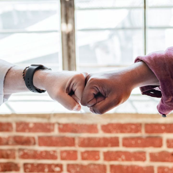 two people hand bumping