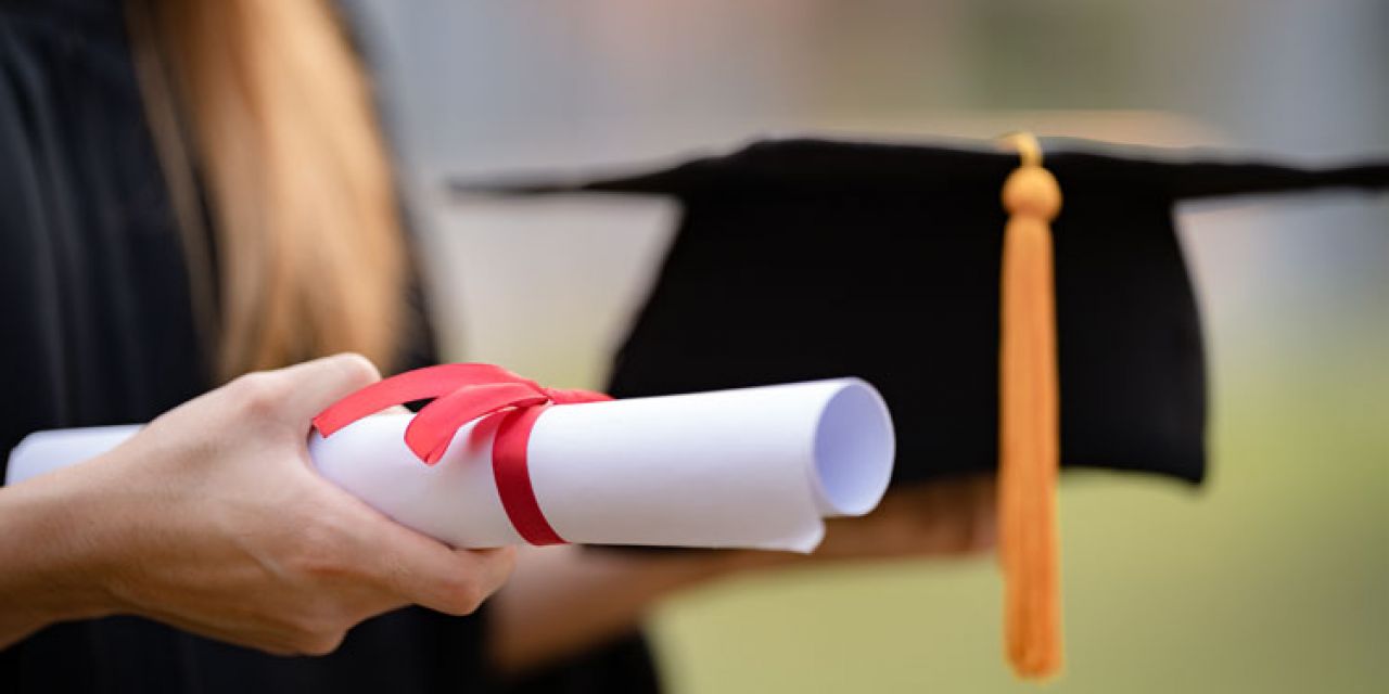 a student carrying his high school diploma